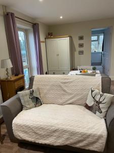 a living room with a couch and a bed at Stag Cottage in Ilkeston