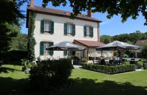 a house with tables and umbrellas in front of it at Renard et l'abeille in Chalmoux