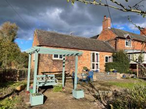 a house with a gazebo in front of it at Stag Cottage in Ilkeston