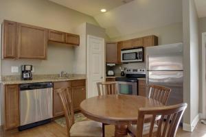 a kitchen with wooden cabinets and a table and a refrigerator at Bavarian Brook Condo 16 in Helen