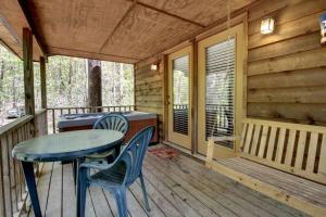 a porch with a table and chairs on a cabin at Bavarian Hideaway 24 in Sautee Nacoochee