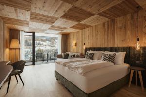 a bedroom with a large bed and wooden walls at Luxury B&B August in Ortisei +65 photos