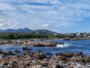 a body of water with rocks in the water at Nerf-af ROOMS at Onrus , Hermanus in Hermanus +25 photos