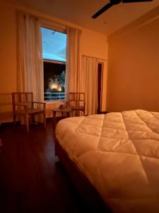 a bedroom with a large bed and a window at Yugm Homes Rishikesh in Narendranagar