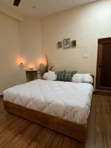 a bedroom with a large white bed in a room at Yugm Homes Rishikesh in Narendranagar