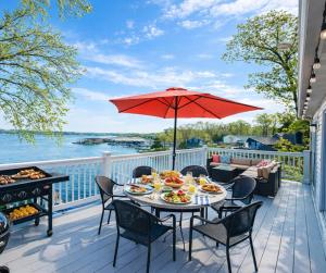 a patio with a table with food and a grill at Sunset and Chill Lakefront 3 Bed 2 Bath Hottub, Firepit Dock in Lake Ozark