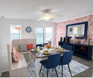 a dining room with a table and blue chairs at Sunset and Chill Lakefront 3 Bed 2 Bath Hottub, Firepit Dock in Lake Ozark