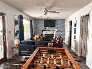 a living room with a foosball table in the middle of a room at Sunset and Chill Lakefront 3 Bed 2 Bath Hottub, Firepit Dock in Lake Ozark