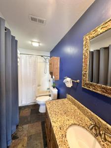 a bathroom with a sink and a toilet and a mirror at Sunset and Chill Lakefront 3 Bed 2 Bath Hottub, Firepit Dock in Lake Ozark +26 photos