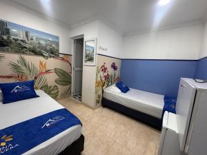 a hotel room with two beds and blue walls at Casa Hotel Manco Mora in Medellín