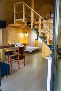 a room with a loft with a bed and a table at Cabana Valea Brazilor in Tutana