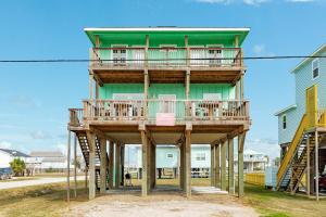 a green building with a deck on top of it at Minutes to the Sand Spacious beautiful relaxing in Surfside Beach