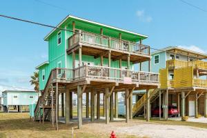 a green and yellow house on wooden posts at Minutes to the Sand Spacious beautiful relaxing in Surfside Beach
