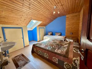 a bedroom with a bed and a sink in a room at La Méliraude in Daverdisse