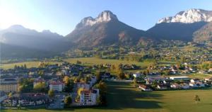 a town in a field with mountains in the background at "Lac'Almie" - Appartement 2 chambres avec Terrasse et Parking in Doussard