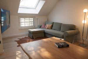 a living room with a couch and a table at Ostfrieschen Ferienwohnung & Spielscheune in Oldendorf