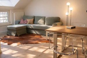 a living room with a couch and a table at Ostfrieschen Ferienwohnung & Spielscheune in Oldendorf +27 photos