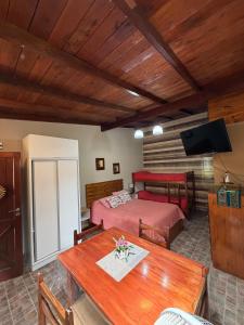 a room with two beds and a table and a television at CABAÑAS MECHI in Mar del Plata