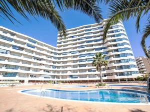 a large apartment building with a swimming pool and palm trees at Blue Beach Apartment in Ifach