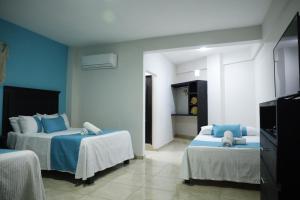 a bedroom with two beds with blue walls at Hotel Tamtokow in Ciudad Valles
