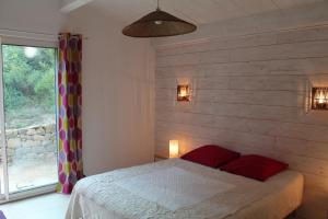 a bedroom with a bed with red pillows and a window at gite les Lavandes à Soyons, à proximité de Valence in Soyons
