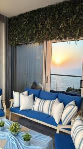 a blue couch in a room with a view of the ocean at برج داماك الجوهرة جدة - Damac al jawharah tower in Jeddah
