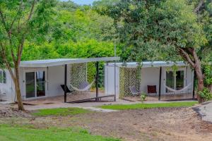 a white house with chairs and trees at Tierra de Gosén in Santa Cruz