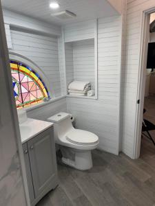 a bathroom with a toilet and a stained glass window at Treehouse Private Village at Barnacle Resort in Big Pine Key