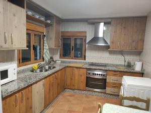 a kitchen with wooden cabinets and a sink and a stove at El refugio de Águeda in Gorafe
