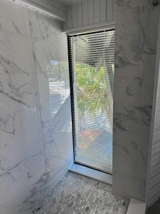 a bathroom with a large glass door with a window at Treehouse Private Village at Barnacle Resort in Big Pine Key