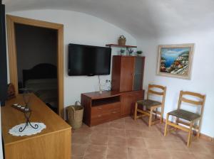 a living room with a television and two chairs at El refugio de Águeda in Gorafe