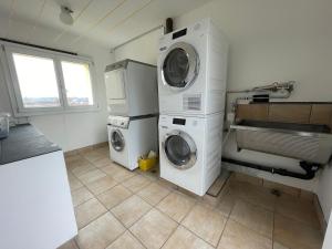 a laundry room with two washing machines and a sink at H95 Studios in Basel City with Basel Card in Basel +2 photos