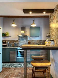 a kitchen with a counter and two stools at Guardastrada Country House in Monteroni dʼArbia