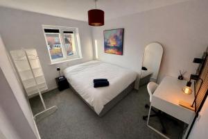a bedroom with a bed and a table and a mirror at Serviced Accommodation, 3 Bed, allocated off road parking, Contractor Ready in Bedford