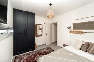a bedroom with a bed and a black door at אשראם-Ashram Eilat in Eilat