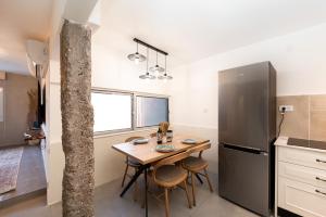 a kitchen with a table and a refrigerator at אשראם-Ashram Eilat in Eilat