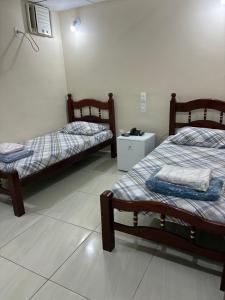a room with two beds and a table in it at Hotel Alameda - Adults Only in Rio de Janeiro