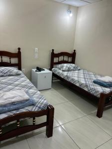 a room with two beds and a night stand at Hotel Alameda - Adults Only in Rio de Janeiro