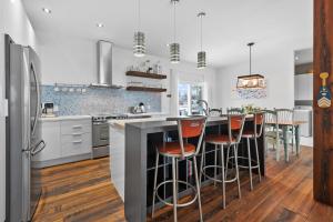 a kitchen with white cabinets and a counter with bar stools at A Getaway on Lake Champlain in Venise-en-Québec