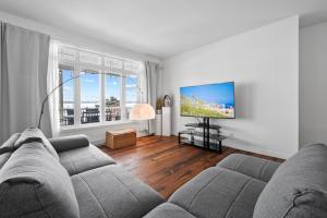 a living room with a couch and a flat screen tv at A Getaway on Lake Champlain in Venise-en-Québec