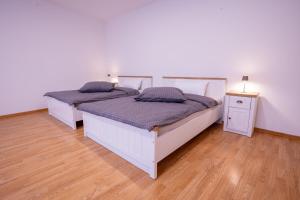 two twin beds in a room with wooden floors at Central Gerolstein Panorama Apartment in Gerolstein