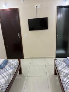 a room with two beds and a flat screen tv at Hotel Alameda - Adults Only in Rio de Janeiro