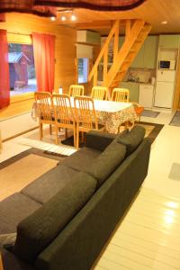 uma sala de estar com um sofá, uma mesa e cadeiras em Vanha Väätänen Cottage em Väätänen