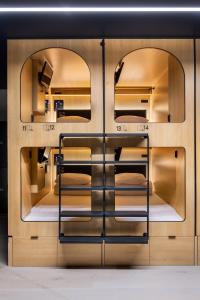 a room with three bunk beds with two mirrors at Capsule Residence in Montreal