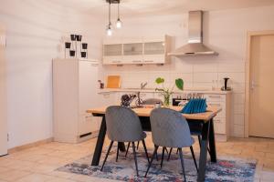 a kitchen with a wooden table and chairs at Central Gerolstein Panorama Apartment in Gerolstein +6 photos