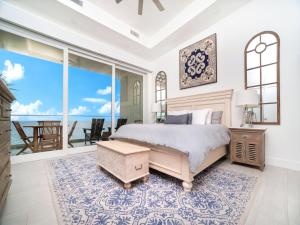 a bedroom with a bed and a view of the ocean at Lighthouse Point Residences in West Bay +105 photos