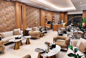 a hotel lobby with tables and chairs and a bar at Ramla Resort in Riyadh