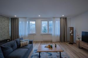 a living room with a couch and a table at Central Gerolstein Panorama Apartment in Gerolstein