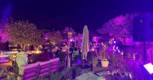 a group of people sitting in a garden with purple lights at Ramla Resort in Riyadh +67 photos