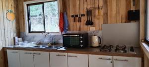 a kitchen with a sink and a microwave at Cabaña con rio y camping in Los Ángeles